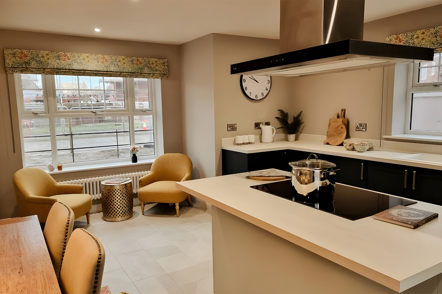 Light kitchen seating area with mustard-yellow armchairs and a large window, creating a bright and relaxed spot for morning coffee or conversation.