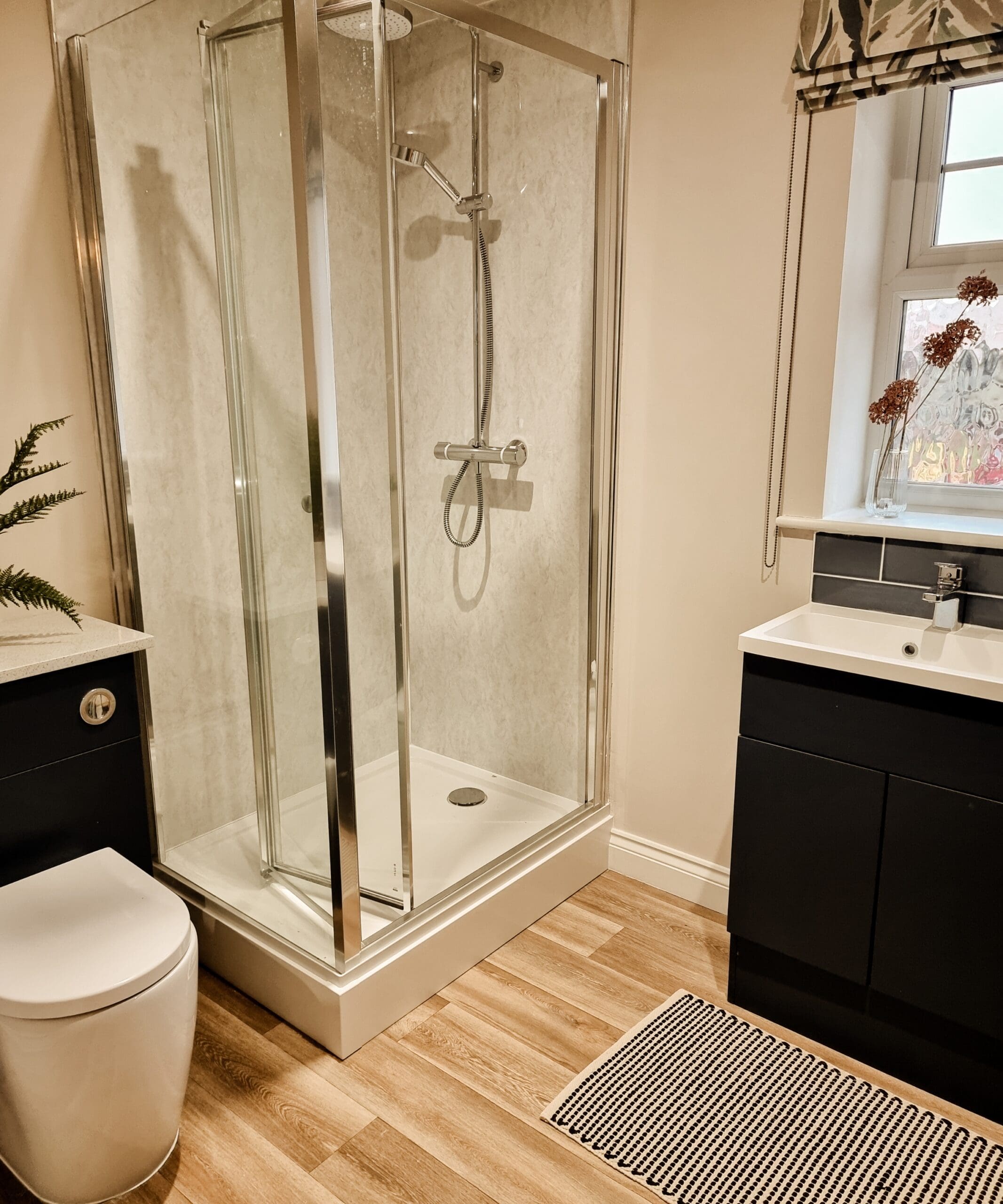 Modern bathroom featuring a glass shower enclosure, sleek cabinetry, and warm natural tones - thoughtfully designed for comfort and ease at The Furlongs, Holland Park.