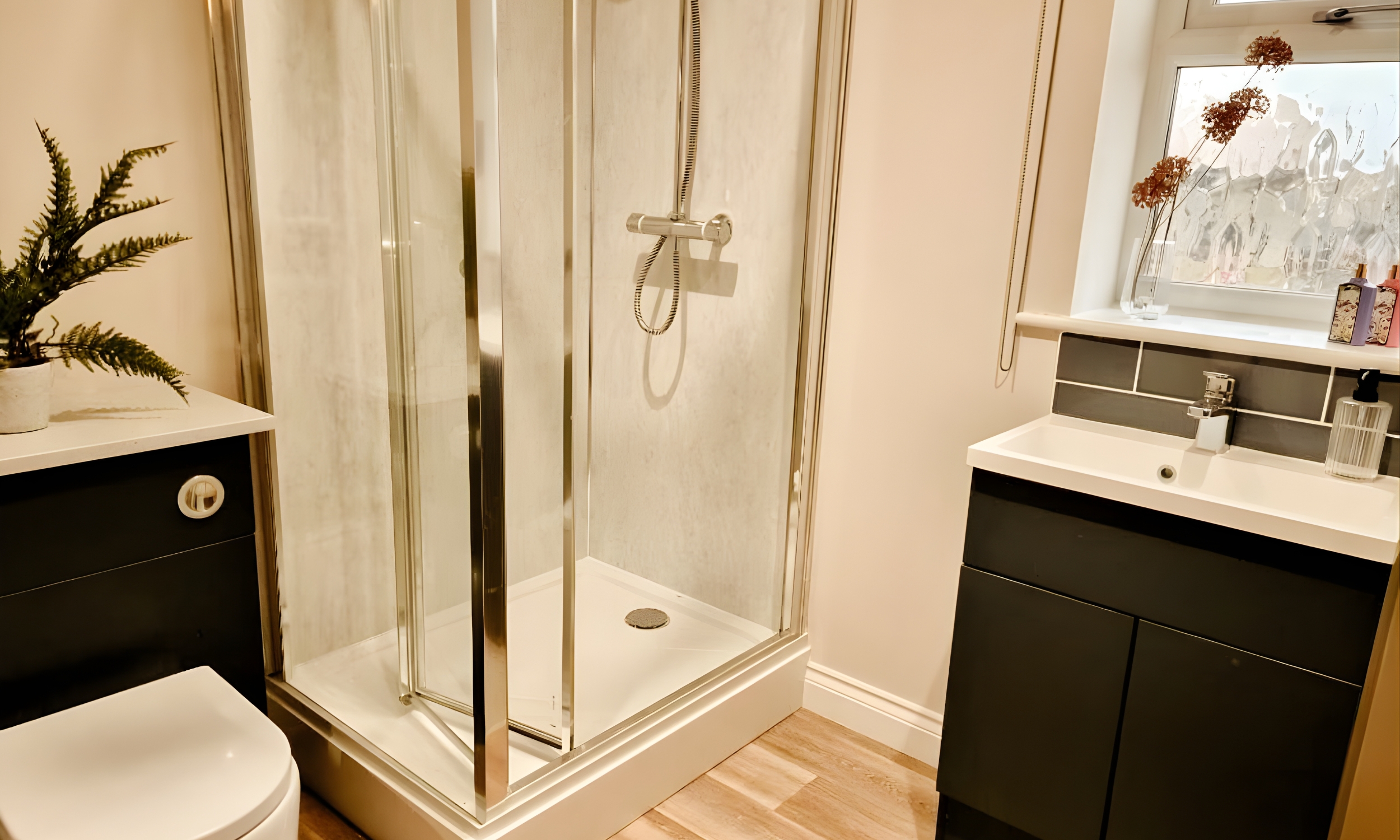 Modern bathroom featuring a glass shower enclosure, sleek cabinetry, and warm natural tones - thoughtfully designed for comfort and ease at The Furlongs, Holland Park.