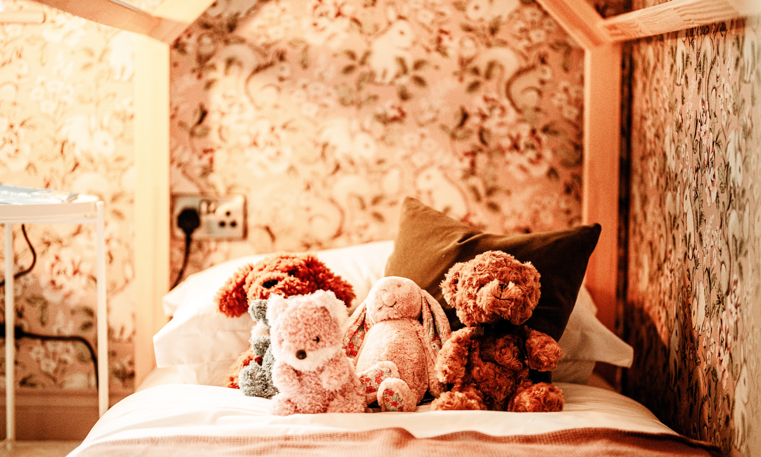 A bright children’s bedroom with squirrel-print wallpaper, woven storage baskets, and a wooden play bed - a playful, welcoming space by Broadgate Homes.