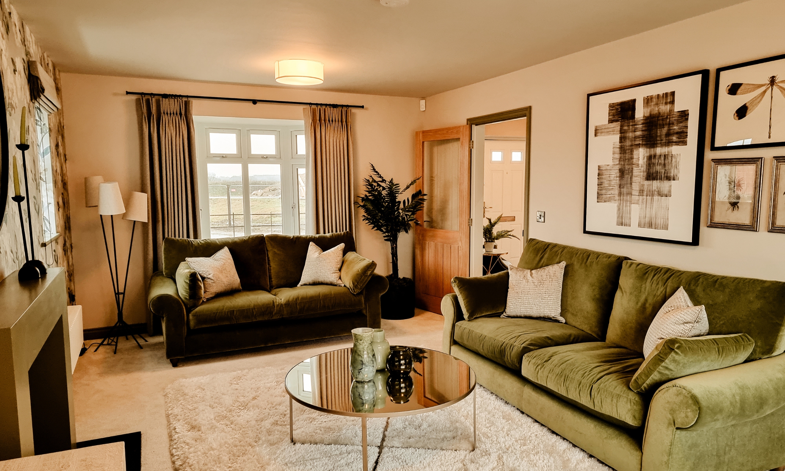 Bright living room with dual sofas, a mirrored coffee table, and natural light streaming through wide windows - designed for calm, contemporary living.