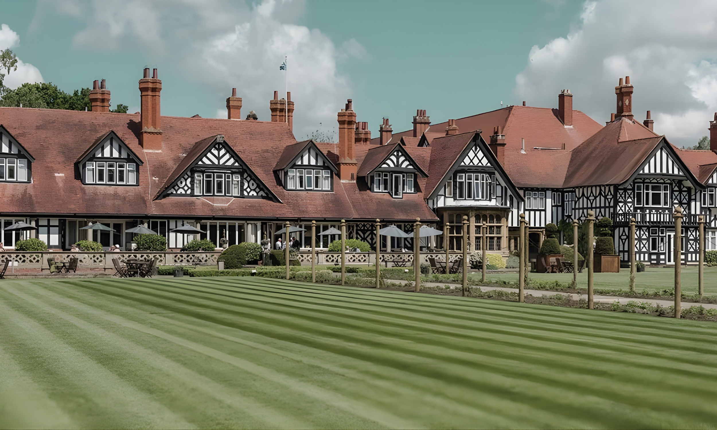 A view of the historic Petwood Hotel in Woodhall Spa, with its distinctive black-and-white timber facade, red roofs and landscaped lawns, showcasing the village’s heritage and character.