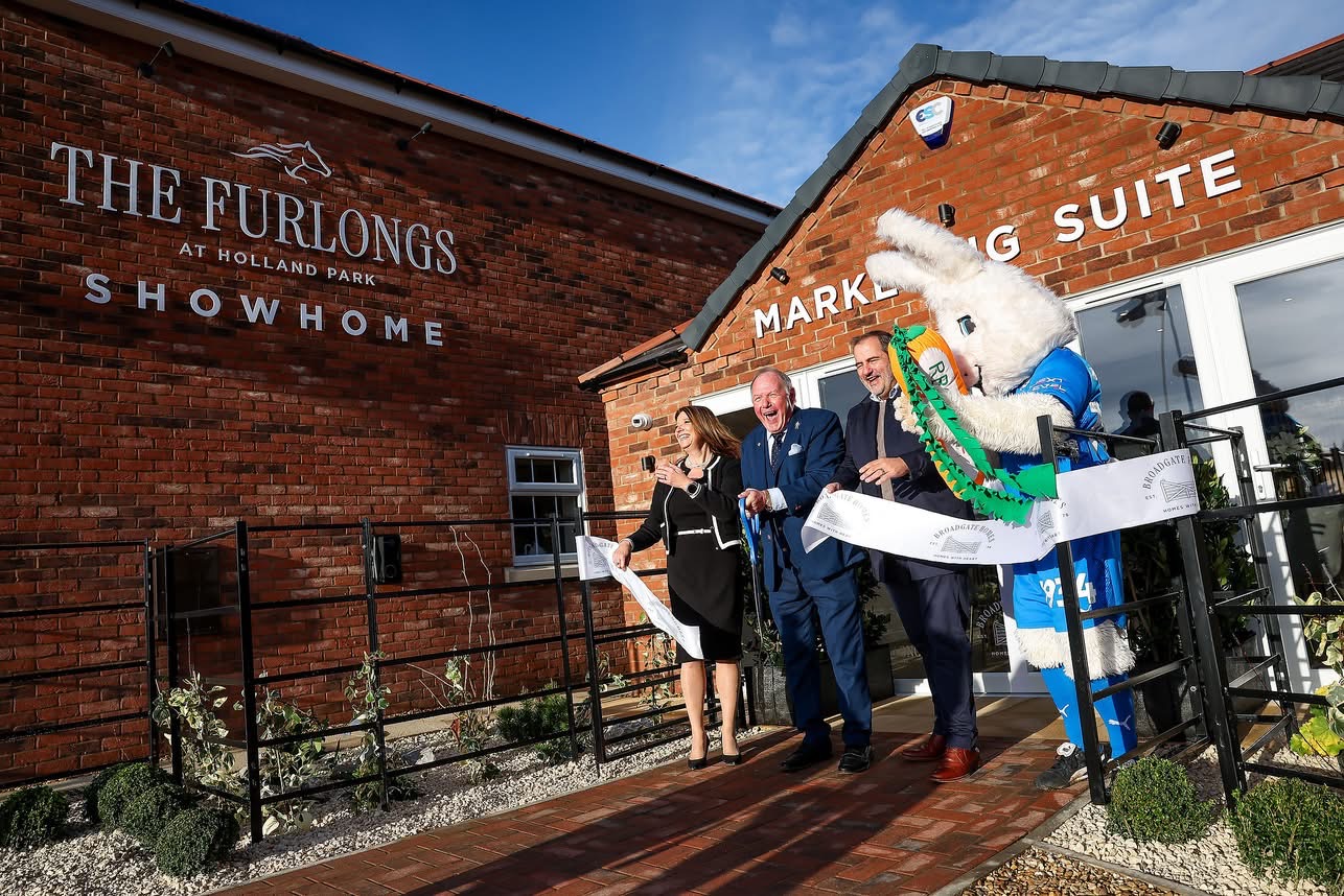 Ribbon-cutting ceremony outside The Furlongs Showhome and Marketing Suite, with Barry Fry, Peter Burrow and Broadgate team members smiling as they open the Sales Hub.