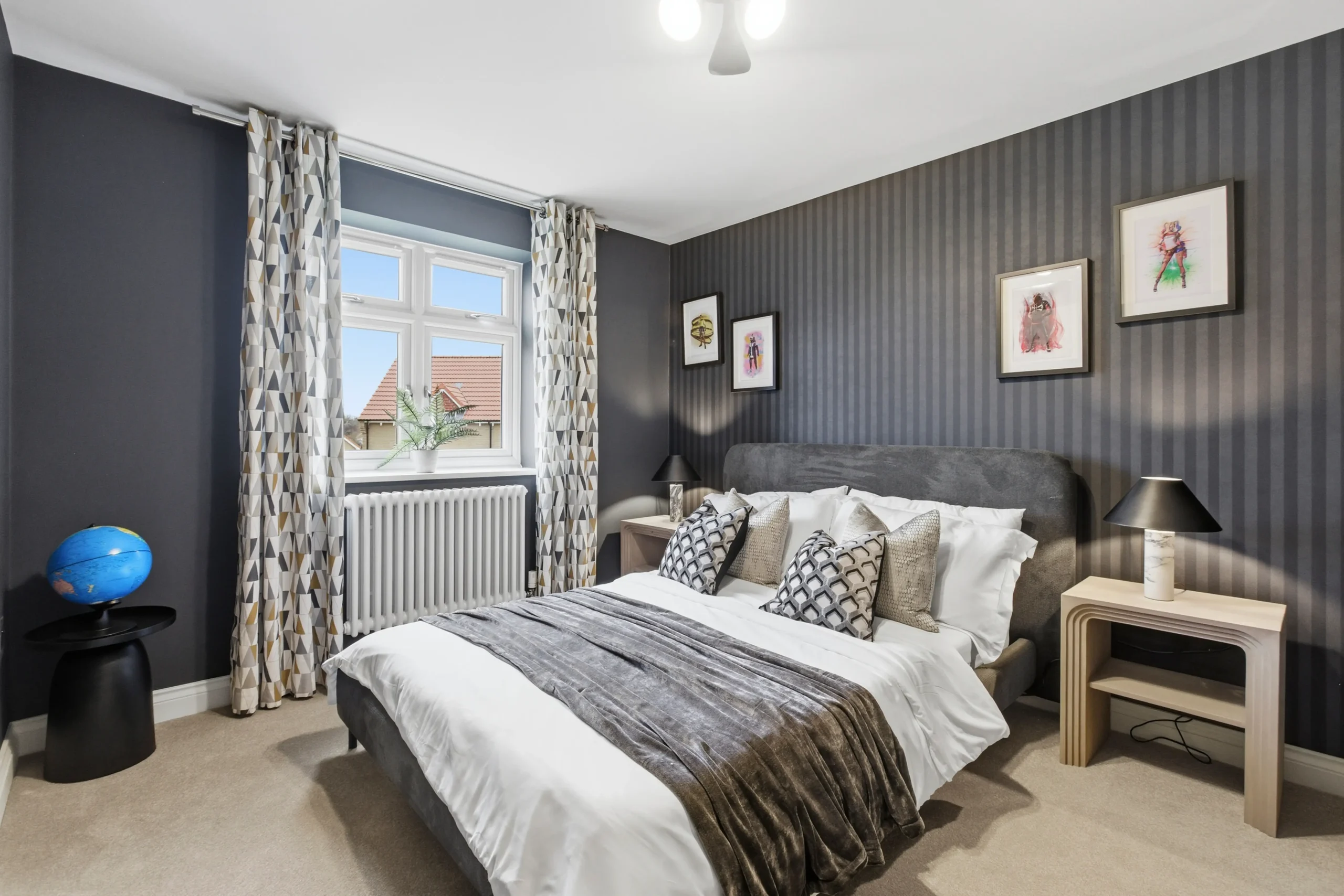 Second bedroom at Gleneagles Drive, Woodhall Spa, with charcoal striped feature wallpaper, upholstered bed, and framed artwork.